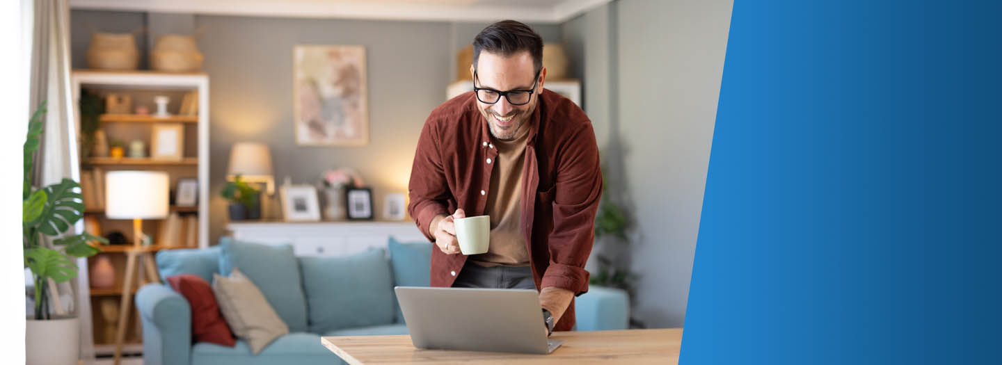 Man smiling while looking at laptop on table